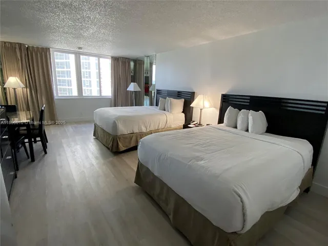 a spacious bedroom with two beds and large windows