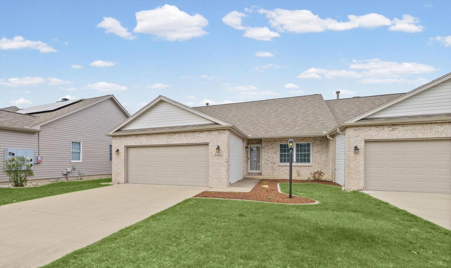 2523 Windward Boulevard, Unit 2523 Champaign, IL 61821 - Photo 2 of 26 a view of a house with a yard and garage