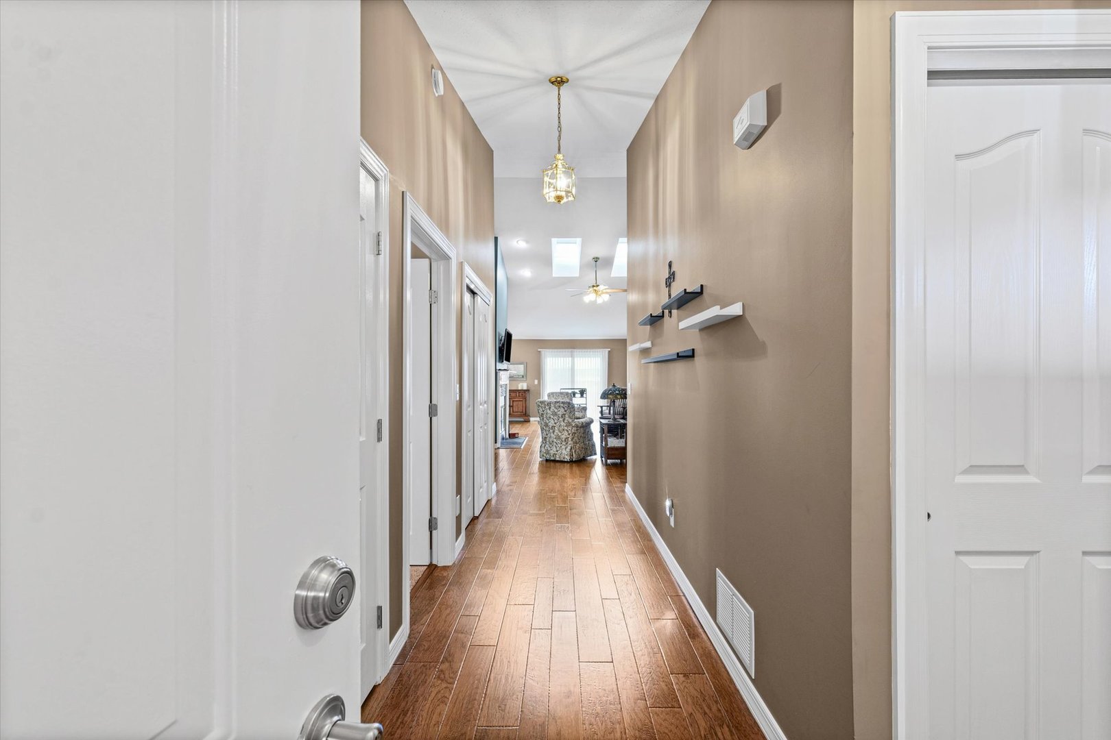 2523 Windward Boulevard, Unit 2523 Champaign, IL 61821 - Photo 3 of 26 a view of a hallway with wooden floor and a bathroom