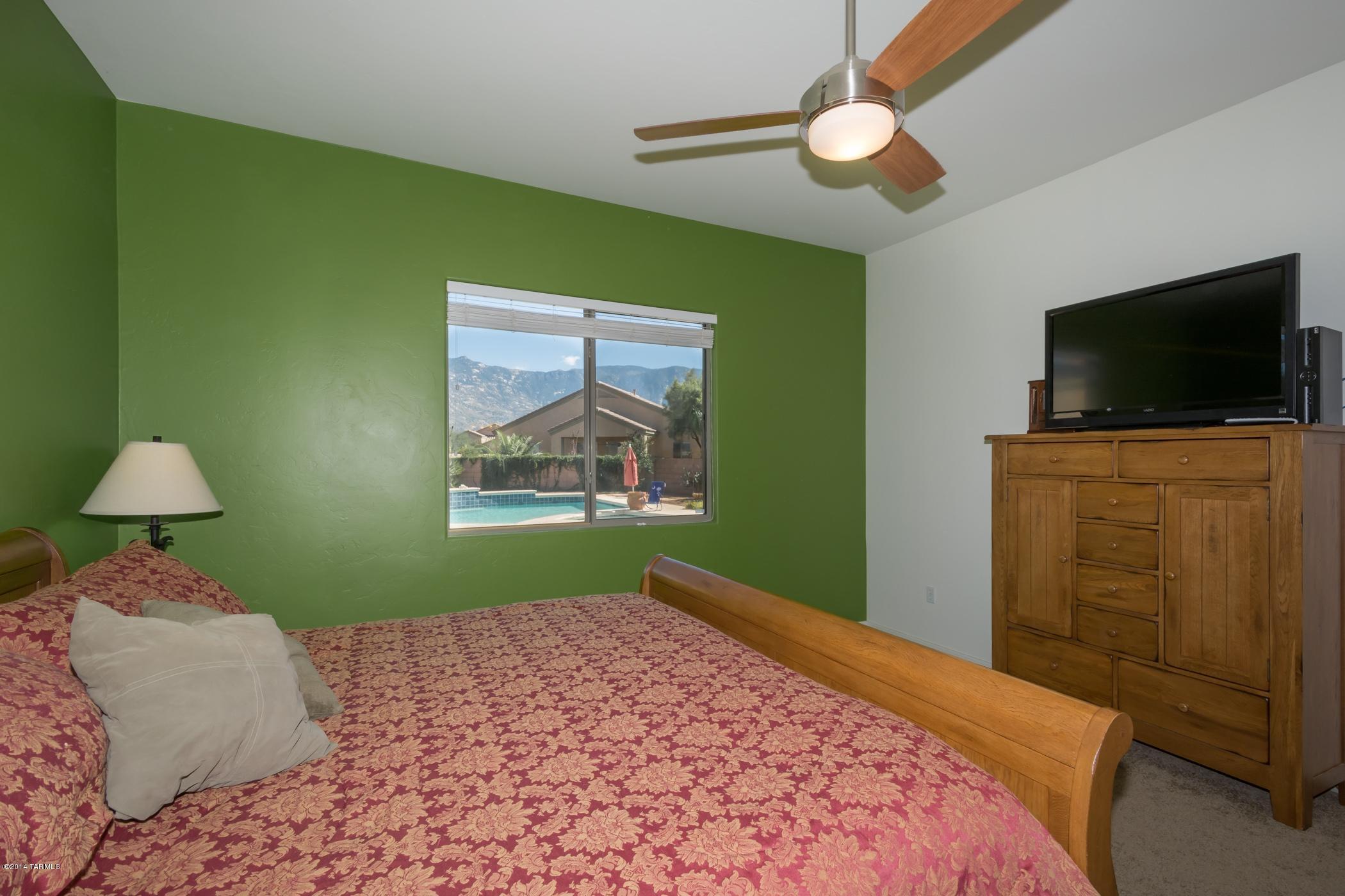 15082 North Holsteiner Road Tucson, AZ 85739 - Photo 23 of 34 a bedroom with a bed and a flat screen tv