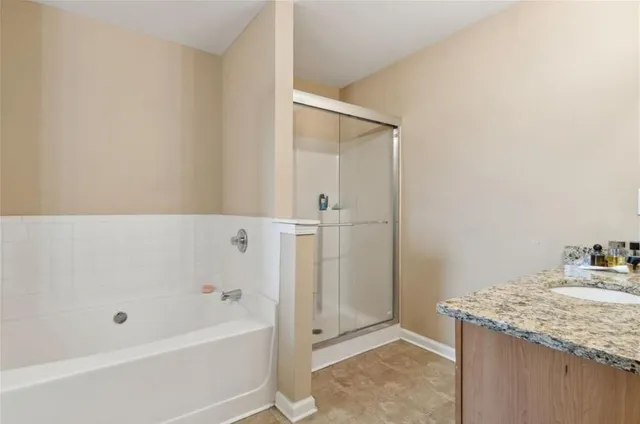 a bathroom with a granite countertop sink and a bathtub