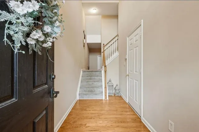 a view of a hallway with wooden floor and front door