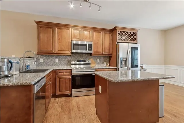a kitchen with stainless steel appliances granite countertop a sink stove and refrigerator