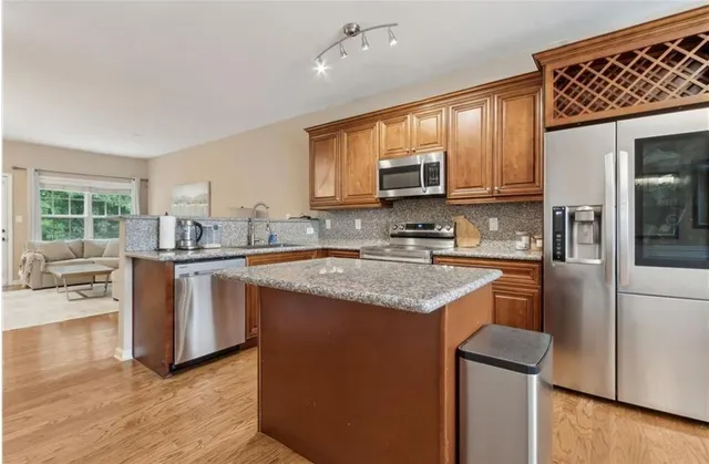 a kitchen with stainless steel appliances granite countertop a stove a sink and a refrigerator