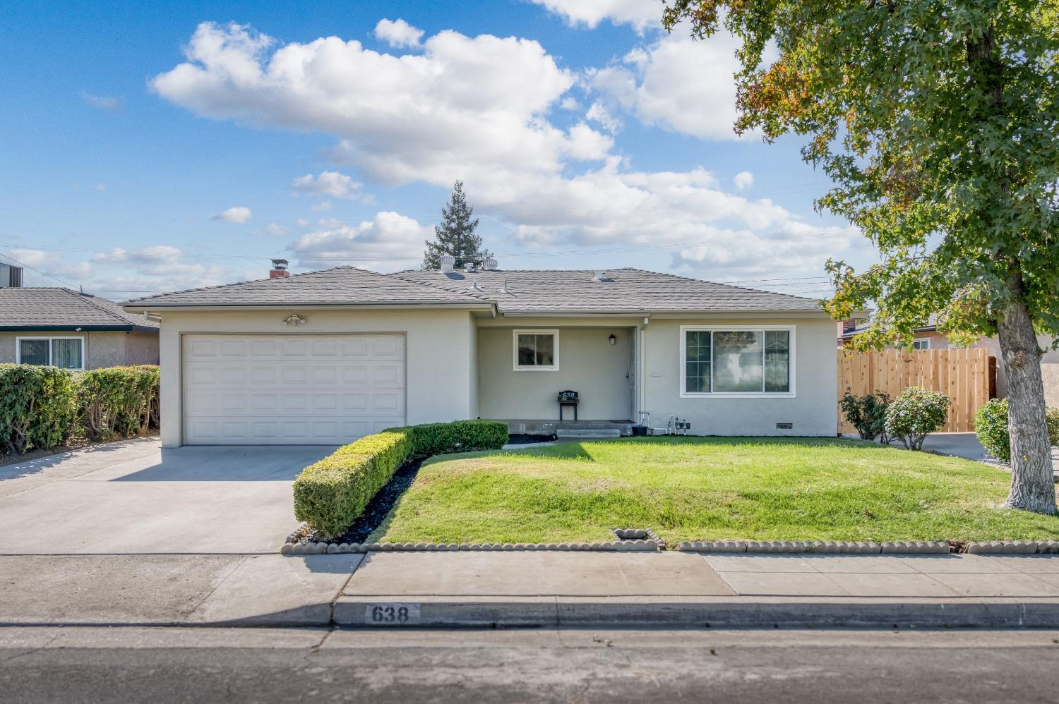 a view of a house with a backyard and a tree