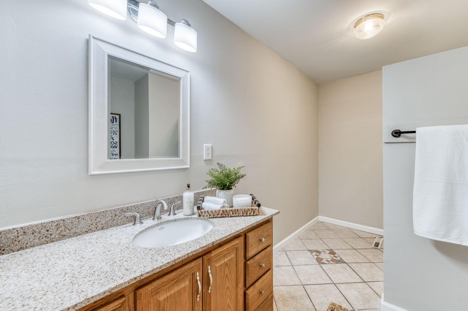 638 West Dennis Drive Clovis, CA 93612 - Photo 19 of 33 a bathroom with a granite countertop sink and a mirror