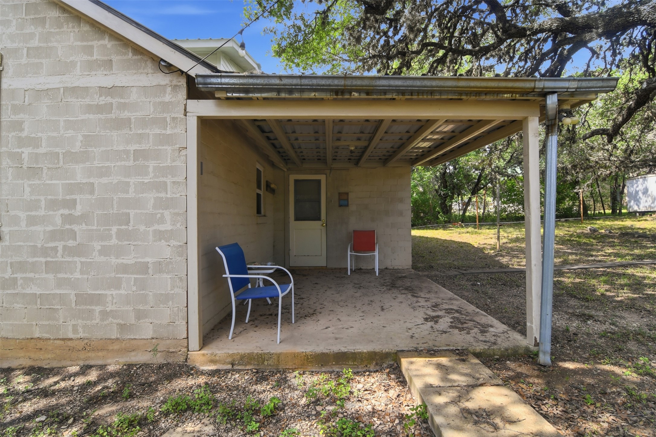 1260 Magers Road Concan, TX 78838 - Photo 14 of 40 A quaint covered patio offers a shaded retreat, perfect for enjoying the peaceful yard.