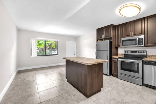 a kitchen with stainless steel appliances granite countertop a stove a sink and a refrigerator