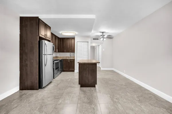 a view of kitchen with refrigerator and cabinets