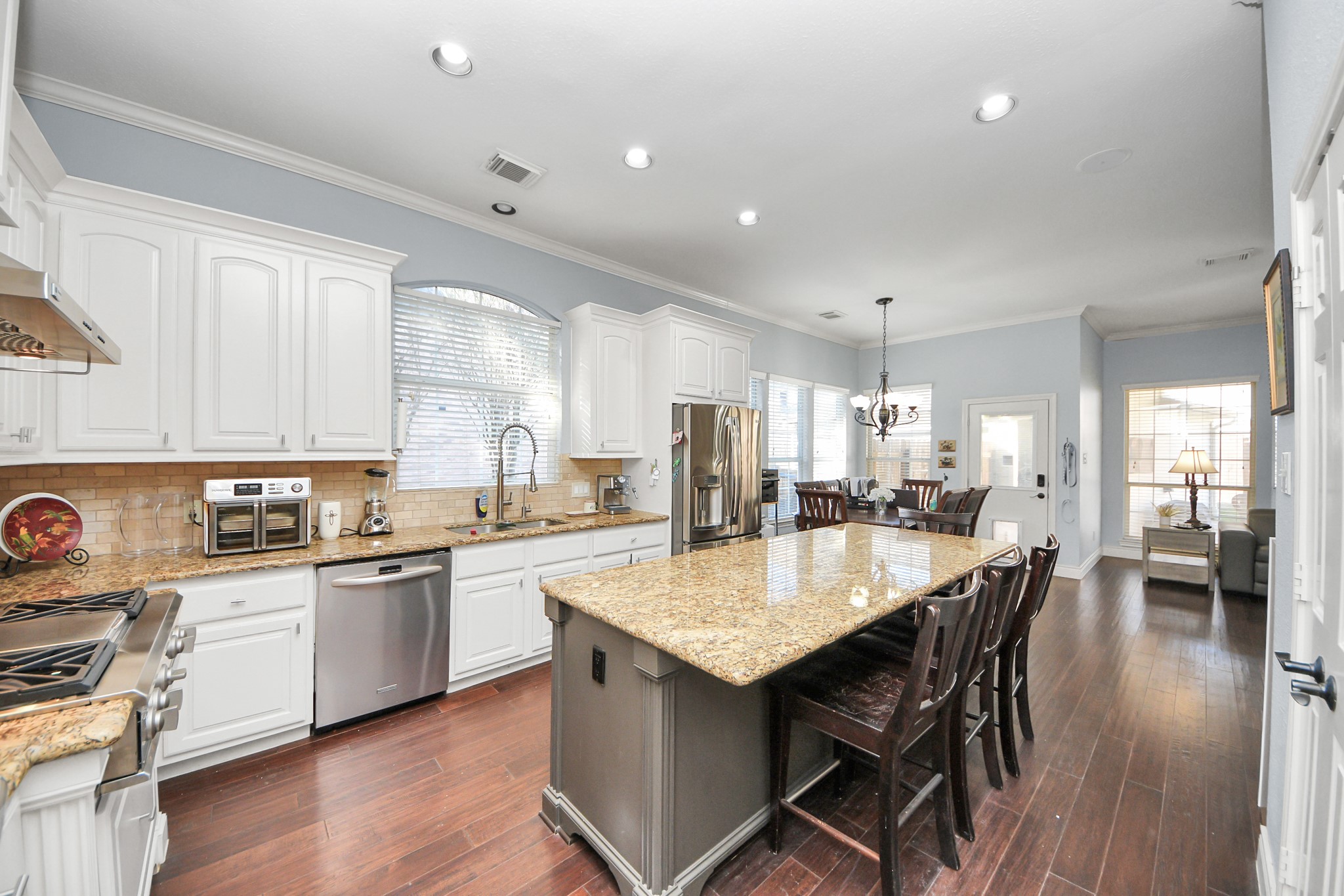 22010 Castlewind Court Katy, TX 77450 - Photo 15 of 41 a kitchen with a dining table chairs stainless steel appliances and cabinets