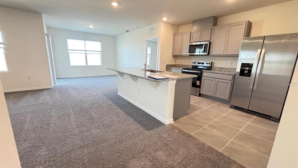 914 Princess Sabal Point Haines City, FL 33844 - Photo 2 of 39 a kitchen with granite countertop a refrigerator and a stove top oven