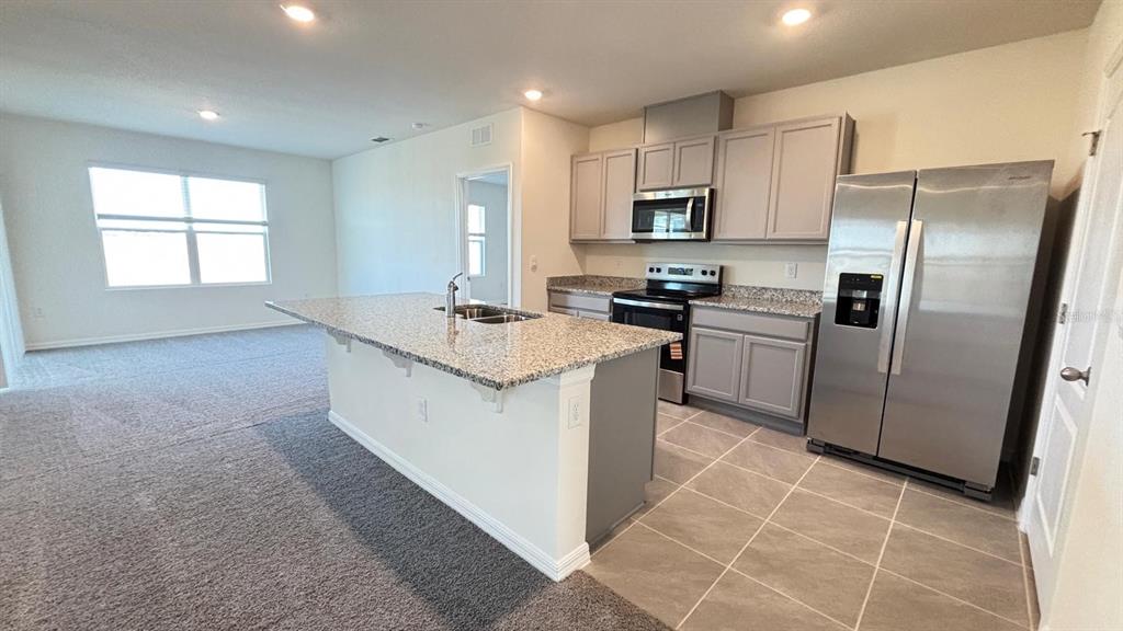 914 Princess Sabal Point Haines City, FL 33844 - Photo 6 of 39 a kitchen with stainless steel appliances granite countertop a refrigerator a sink a stove a microwave and island