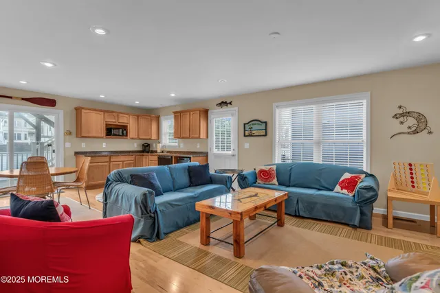 a living room with furniture a large window and kitchen view