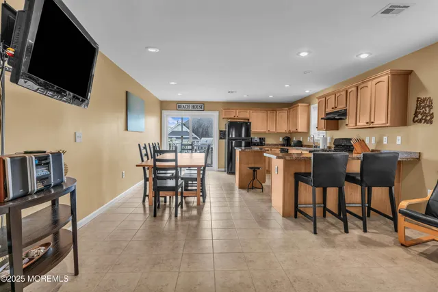 a kitchen with stainless steel appliances kitchen island granite top and refrigerator