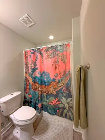 a bathroom with a toilet sink and shower curtain