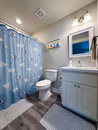a bathroom with a toilet sink double vanity and mirror