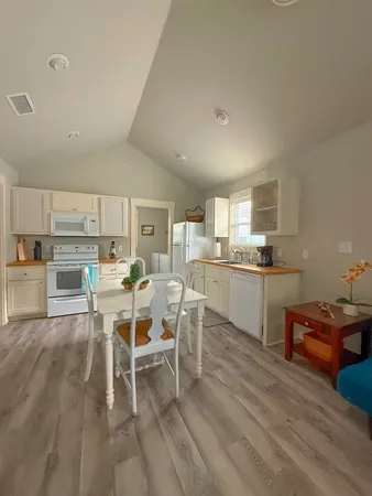 a kitchen with a dining table chairs and view living room
