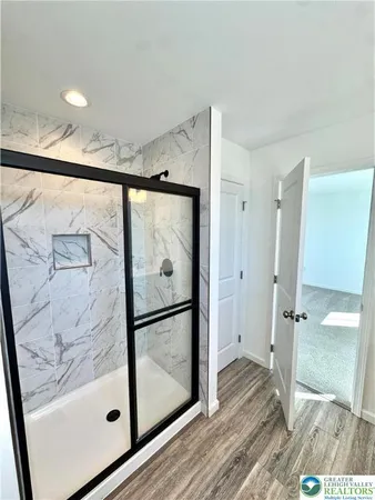 a bathroom with a glass shower door and a mirror
