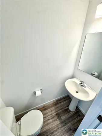 a bathroom with a toilet a sink and mirror