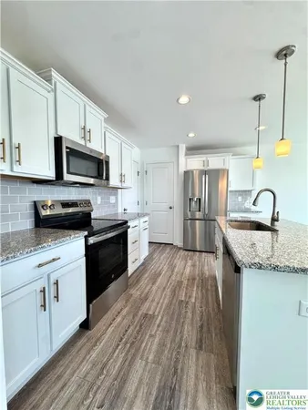 a kitchen with granite countertop a sink and steel appliances