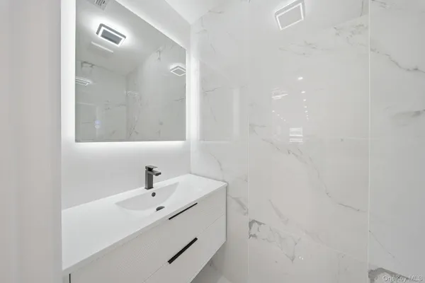a bathroom with a sink a shower and a mirror