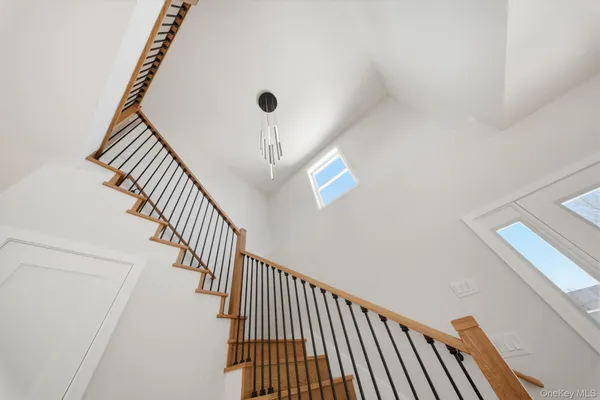 a view of staircase with railing and white walls