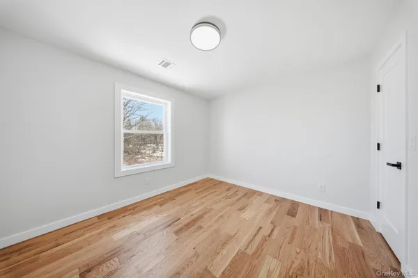 a view of a room with wooden floor and window