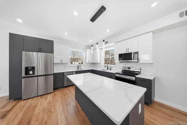 a kitchen with stainless steel appliances a refrigerator sink and microwave