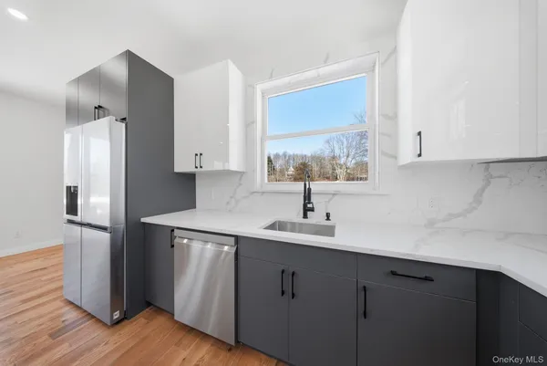 a kitchen with a sink cabinets stainless steel appliances and a window
