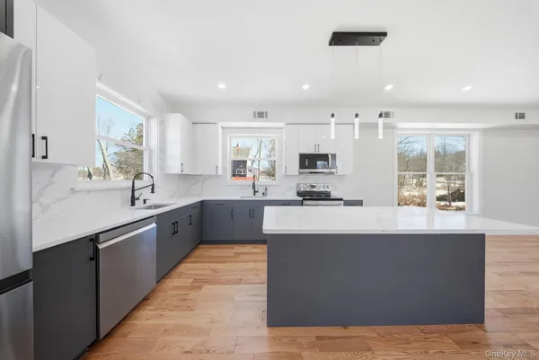 a large kitchen with stainless steel appliances lots of counter space and a sink