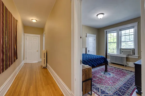 a view of a bedroom with furniture and wooden floor