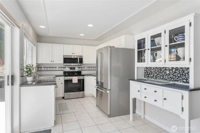 a kitchen with granite countertop a refrigerator and a stove top oven