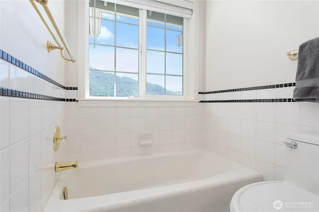 a bath tub sitting next to a white toilet and a shower