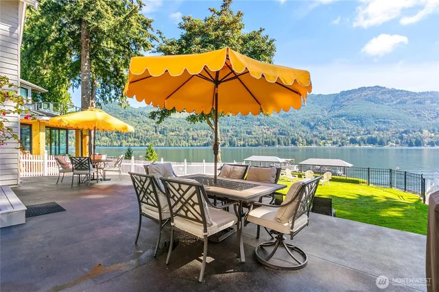 a view of a swimming pool with a table and chairs under an umbrella
