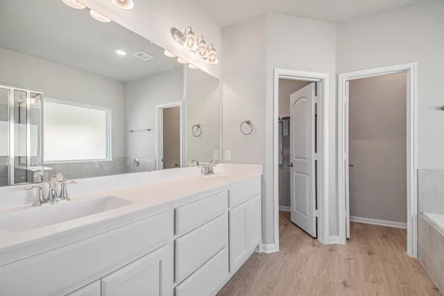 a spacious bathroom with a double vanity sink mirror and shower