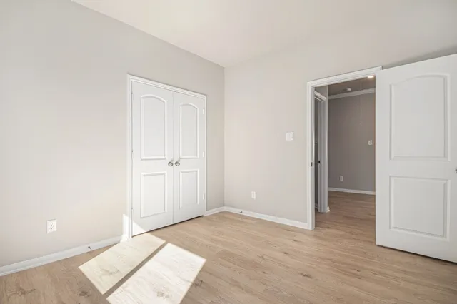an empty room with wooden floor and closet