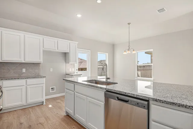 a kitchen with granite countertop white cabinets and white appliances
