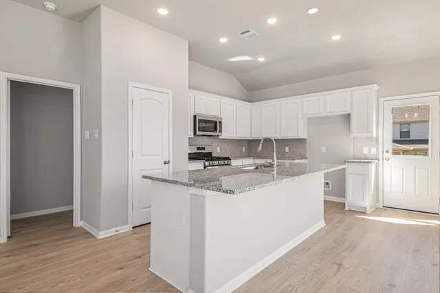 a kitchen with stainless steel appliances granite countertop a sink stove and refrigerator