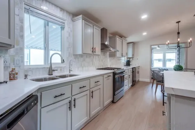 a kitchen with stainless steel appliances kitchen island granite countertop a stove a sink a refrigerator and a cabinets