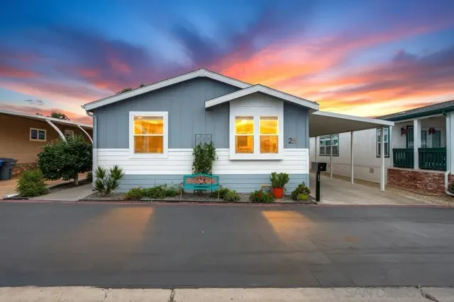 a view of a house with a yard and potted plants