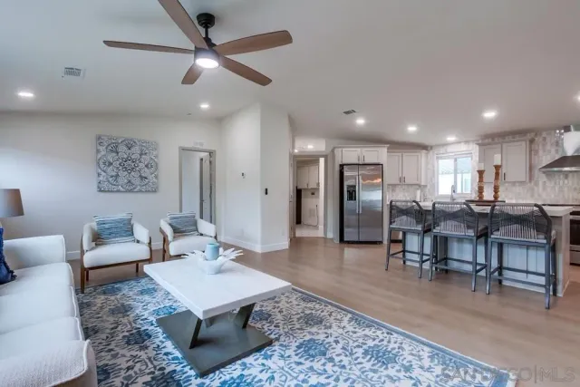 a living room with furniture a fireplace and kitchen view