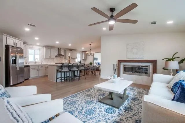 a living room with furniture kitchen view and a chandelier