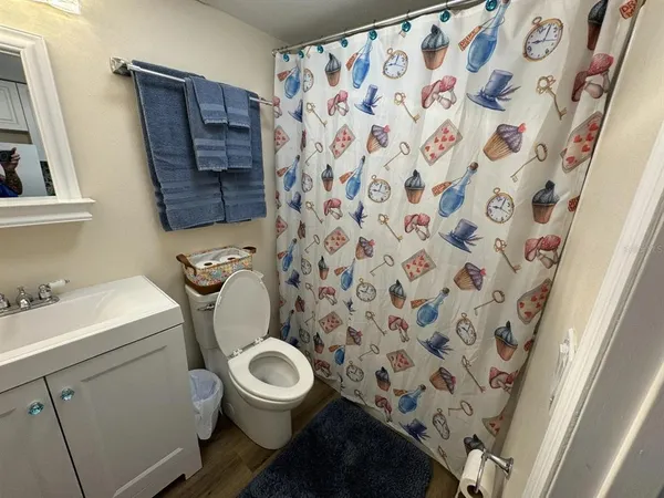 a bathroom with a granite countertop toilet sink and mirror