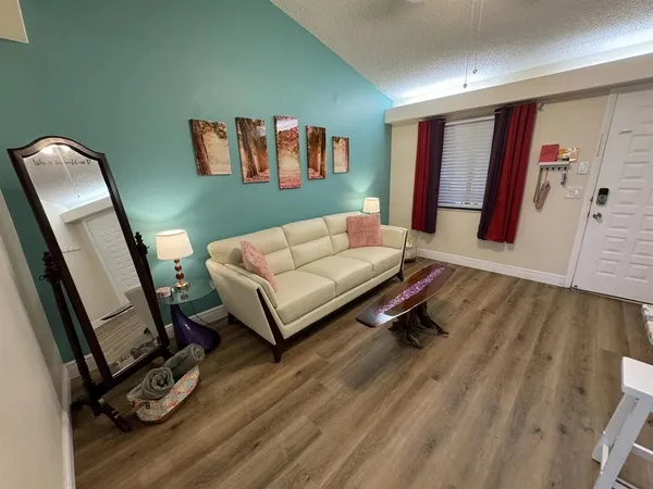 a living room with furniture and a wooden floor