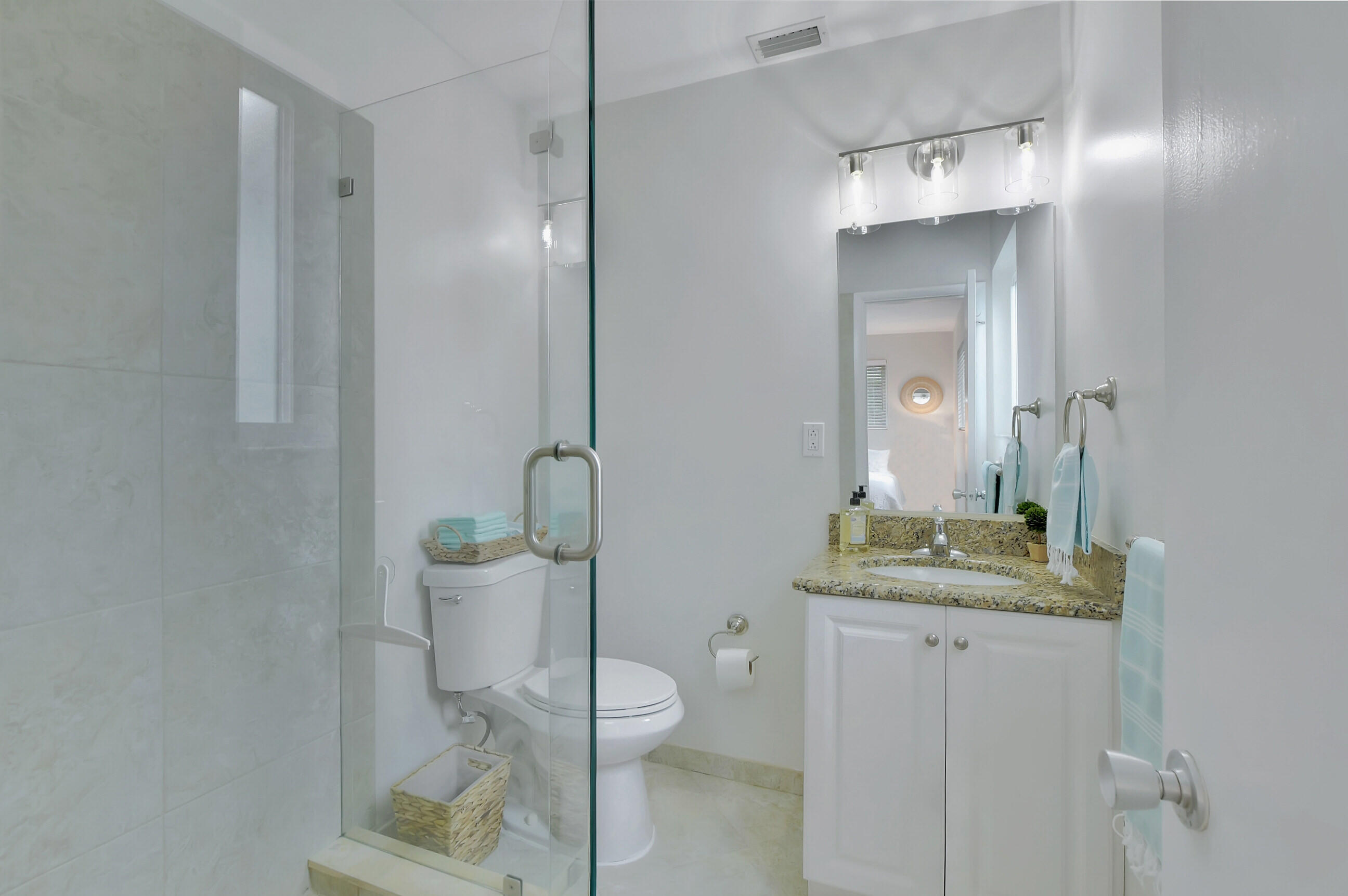 1133 Southwest 7th Street Boca Raton, FL 33486 - Photo 9 of 20 a bathroom with a granite countertop sink a toilet and a mirror