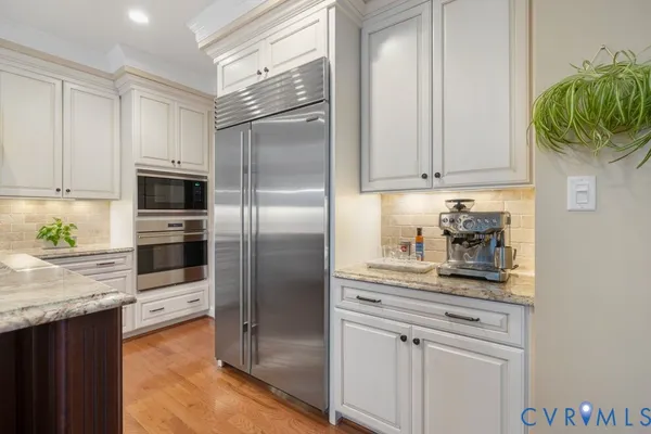 a kitchen with stainless steel appliances granite countertop a refrigerator and a stove