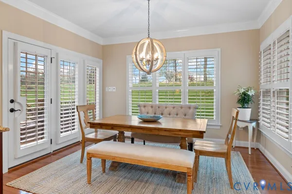 a dining room with furniture a chandelier and wooden floor