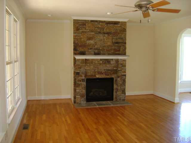 305 Waterville Street Raleigh, NC 27603 - Photo 2 of 8 an empty room with a fireplace and windows