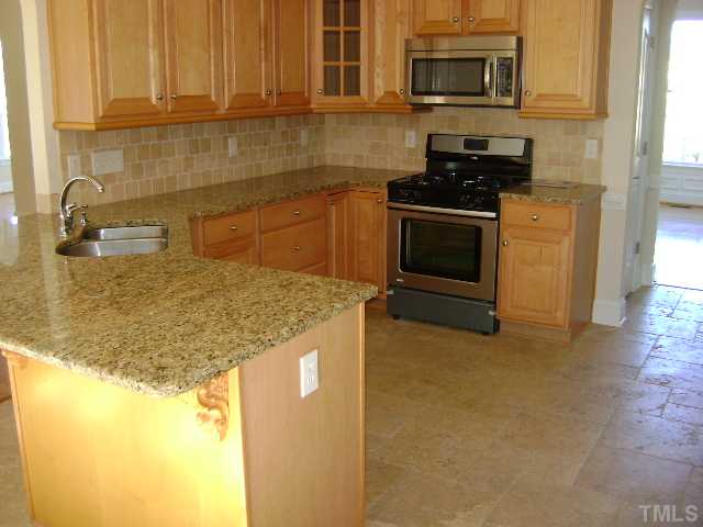 305 Waterville Street Raleigh, NC 27603 - Photo 3 of 8 a kitchen with granite countertop a sink a stove top oven and cabinetry