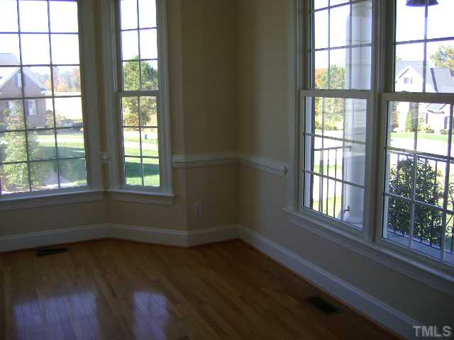 305 Waterville Street Raleigh, NC 27603 - Photo 4 of 8 an empty room with wooden floor and windows